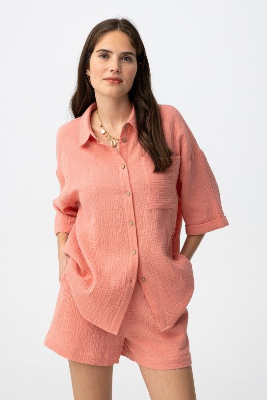  Camisa oversize de color rosa, manga corta, bolsillo amplio delante y botones al centro.  100% COTTON